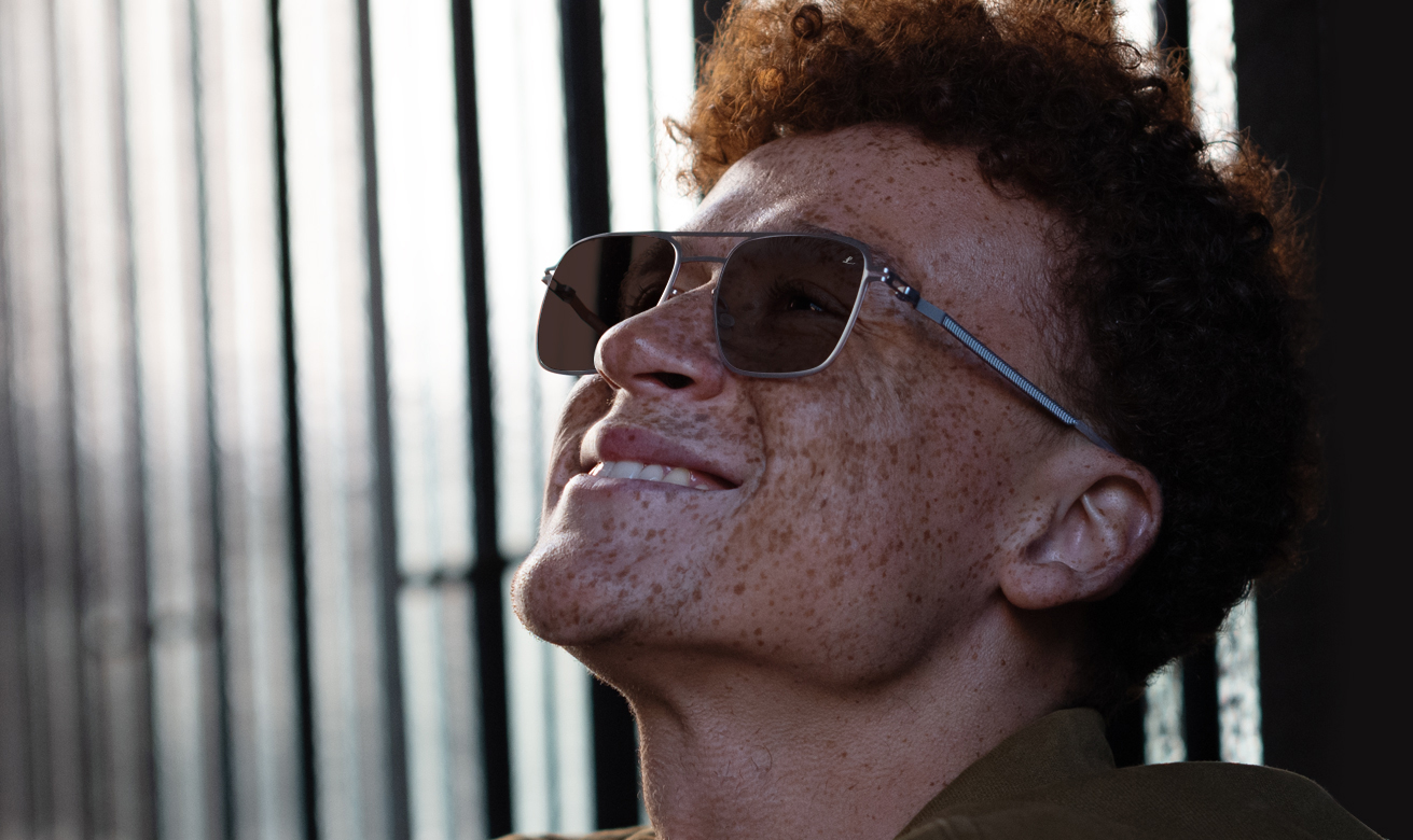 Junger Mann mit Brille mit Leica-Brillengläsern mit TRANSITIONS XTRACTIVE Technologie