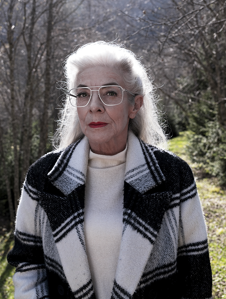 Frau mit Brille mit Premium-Brillengläsern von Leica steht in der Natur