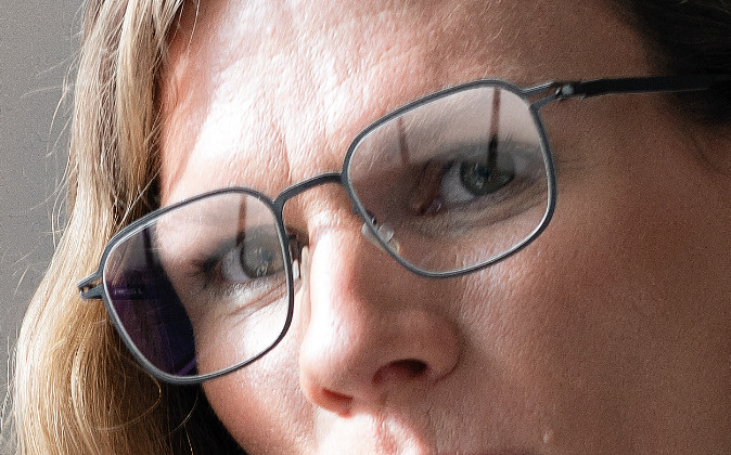 Frau mit Brille mit Brillengläsern ohne AQUADURA VISION Beschichtung