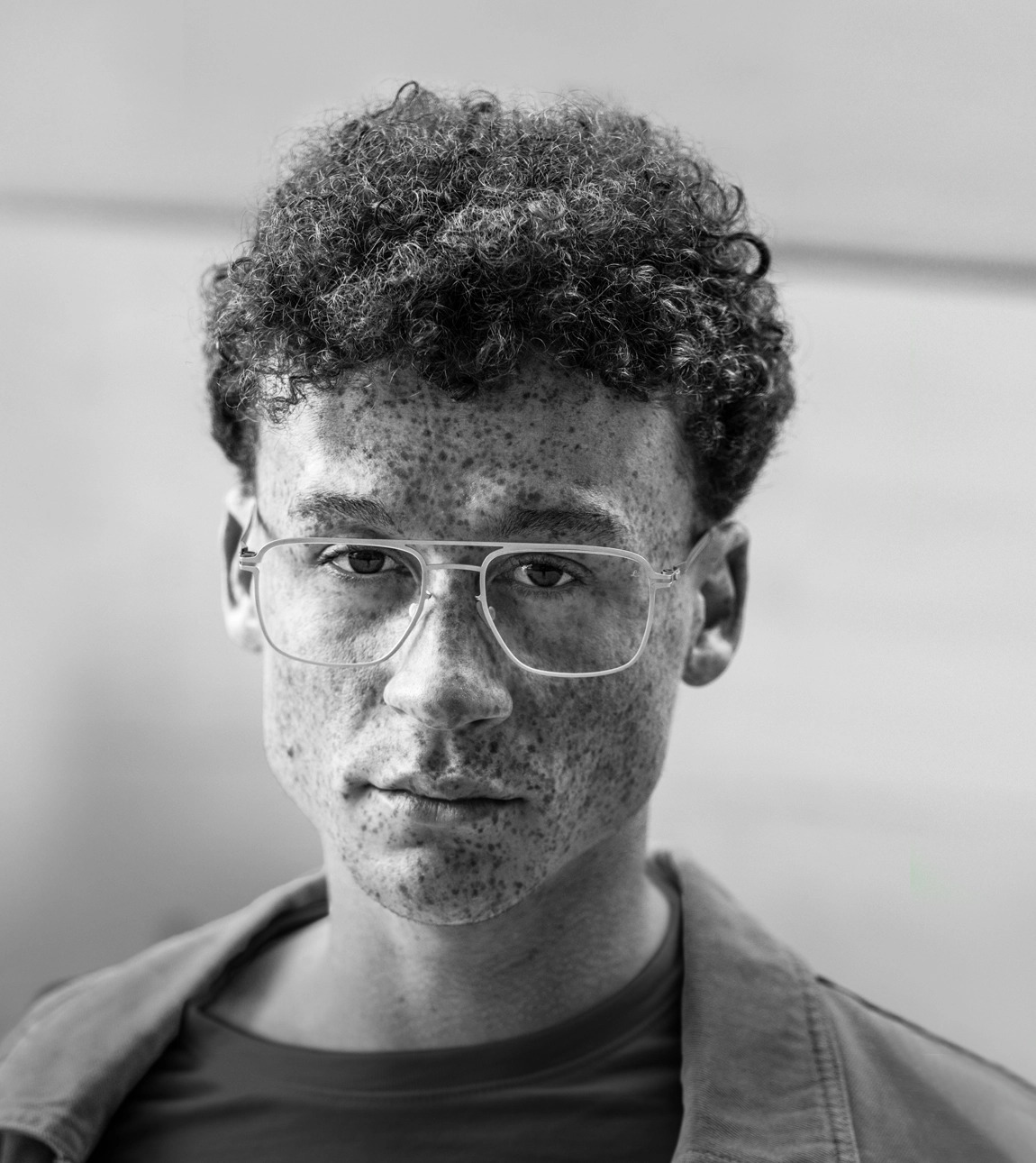 Junger Mann mit Brille mit Premium-Brillengläsern von Leica